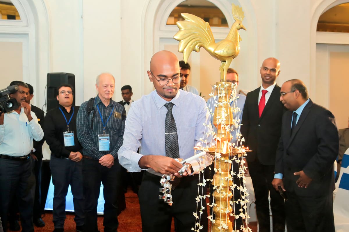 A delegate lighting a traditional brass oil lamp at the 2023 conference opening