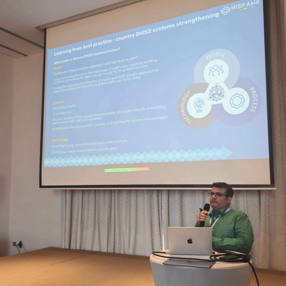 A presenter discussing people, process, and technology during a parallel session