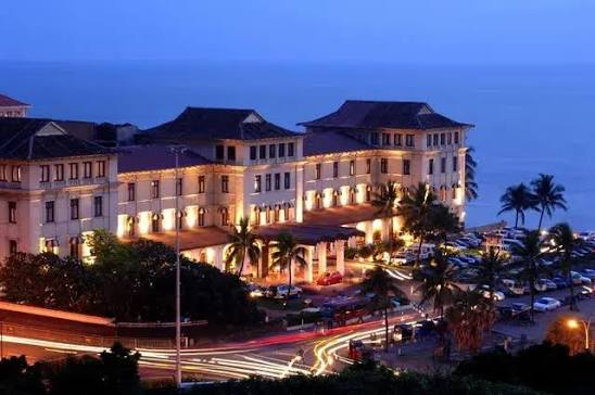 Galle Face Hotel glowing at dusk beside the Colombo coast